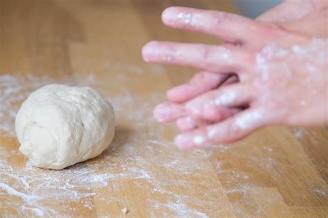 Premium Photo Kneading Dough On The Wooden Table Lump Of Dough Next