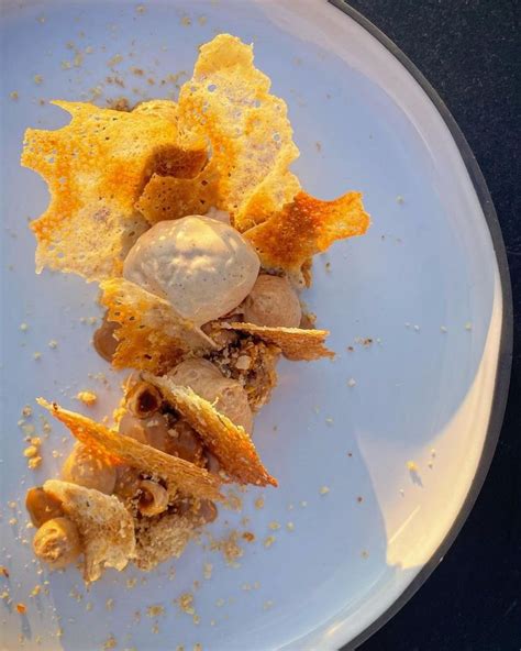 A White Plate Topped With Food On Top Of A Blue Table Cloth Covered In Dirt