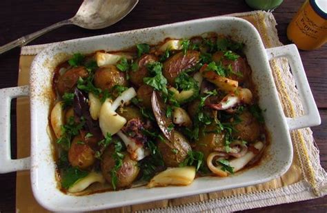 A Casserole Dish With Meat And Vegetables In It On A Place Mat Next To