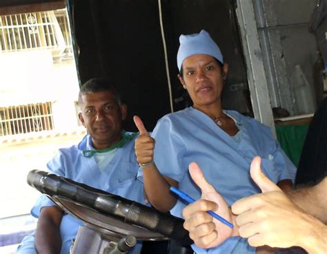 Two Doctors Giving The Thumbs Up Sign In Front Of A Man And Woman