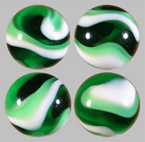 Four Green And White Marbles Sitting On Top Of Each Other