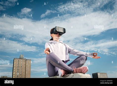 Woman Sitting Wearing Vr Goggles And Yoga Meditating Outside Urban