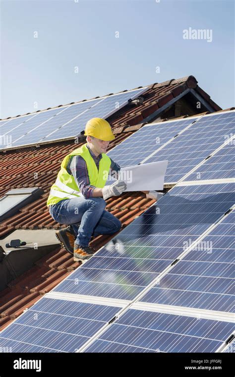 Engineer On Roof Controlling Solar Panels Stock Photo Alamy