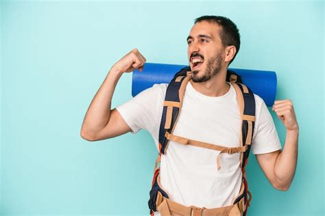 Homem Jovem Alpinista Caucasiano Isolado Em Fundo Azul Levantando O