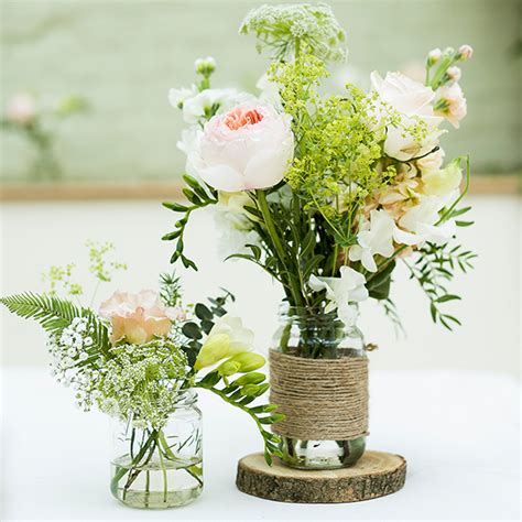 Jam Jars Wrapped In Hessian And Filled With Wedding Flowers Create A