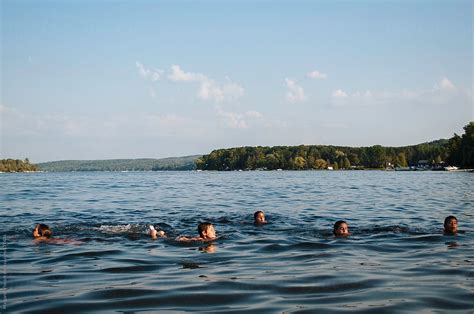 "A Group Of Children Swimming In A Lake" by Stocksy Contributor "Margaret Vincent" - Stocksy