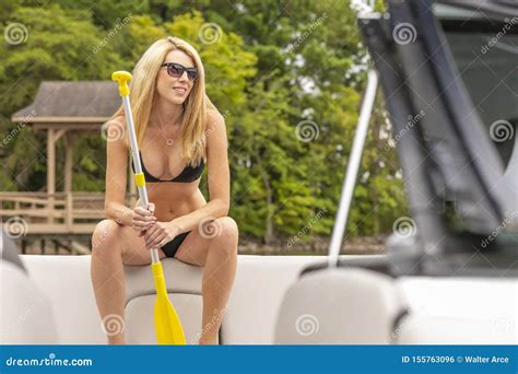 Beautiful Bikini Model Relaxing On A Boat By The Docks Stock Photo