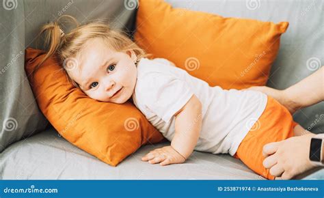 Female Hands Touching A Little Girl Lying On A Sofa Stock Photo Image