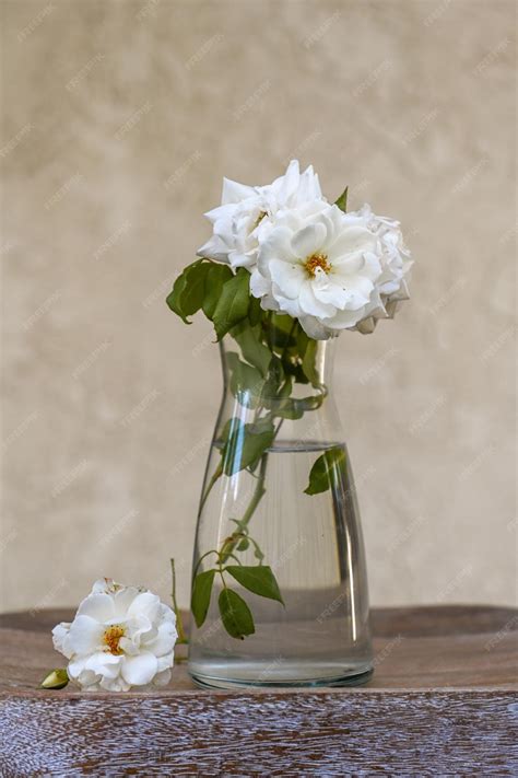 Premium Photo White Roses In A Glass Vase On A Textured Wooden Board