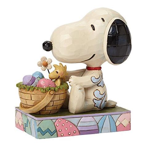 a figurine of a snoopy dog holding a basket with eggs in it