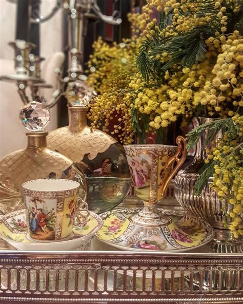 A Table Topped With Dishes And Cups Filled With Flowers