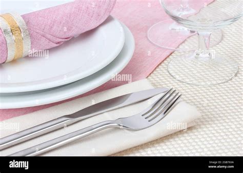 Table setting with fork, knife, plates, and napkin Stock Photo - Alamy