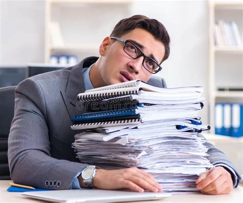 Sobrecargado Con El Empleado De Trabajo Bajo La Carga De Papeleo Foto