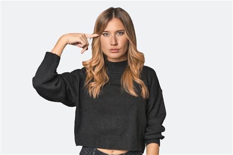 Premium Photo Caucasian Blonde Woman In Studio Pointing Temple With Finger Thinking Focused On