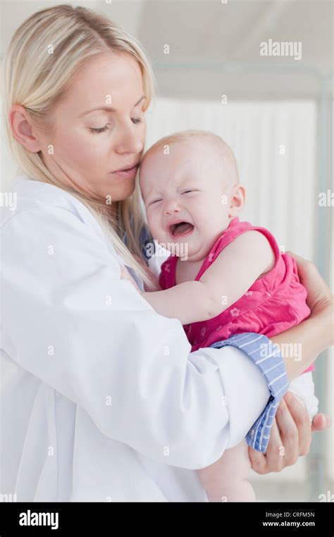 Doctor Hugging Crying Baby Stock Photo Alamy