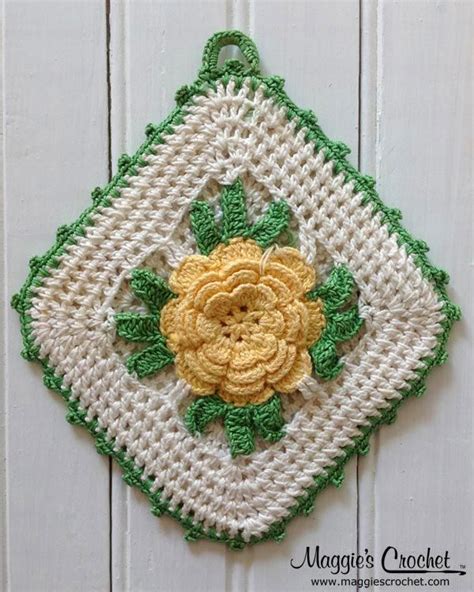 a crocheted wall hanging with a yellow flower on it's center piece