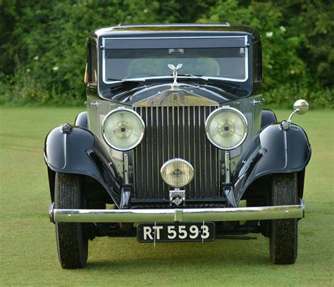 an antique car is parked on the grass