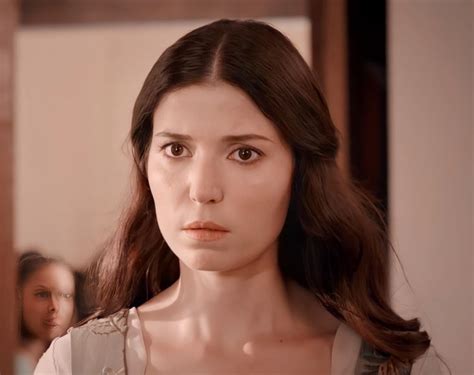 A Woman With Long Brown Hair Standing In Front Of A Mannequin