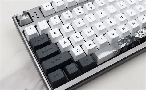 A Computer Keyboard Sitting On Top Of A White Table Next To A Black And