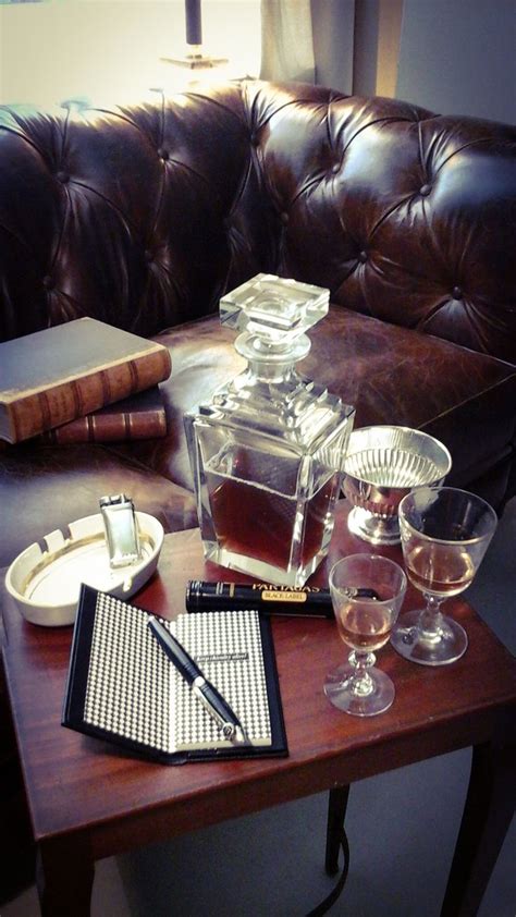 A Table With Glasses Pen And Notebook On It Next To A Brown Leather Couch