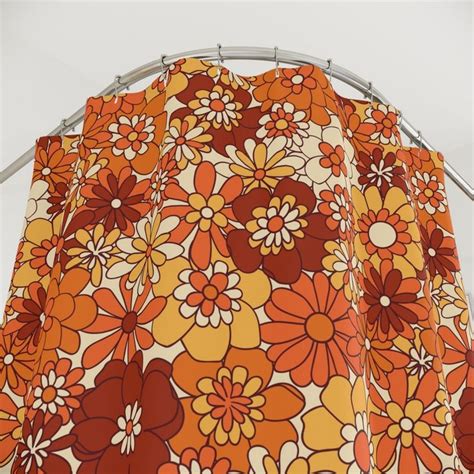 An Orange And Yellow Flowered Curtain Hanging From A Metal Rod