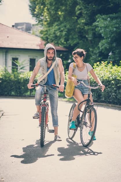 Premium Photo Couple Of Friends Young Man And Woman Riding Bike