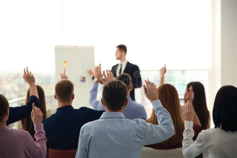 People Raising Hands To Ask Questions At Business Training Stock Photo