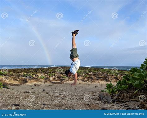 Man Does Handstand on Coral Rocks on the Beach with Rainbow Stock Image ...