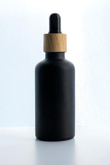 Premium Photo Dark Frosted Glass Cosmetic Bottle With A Dropper On A