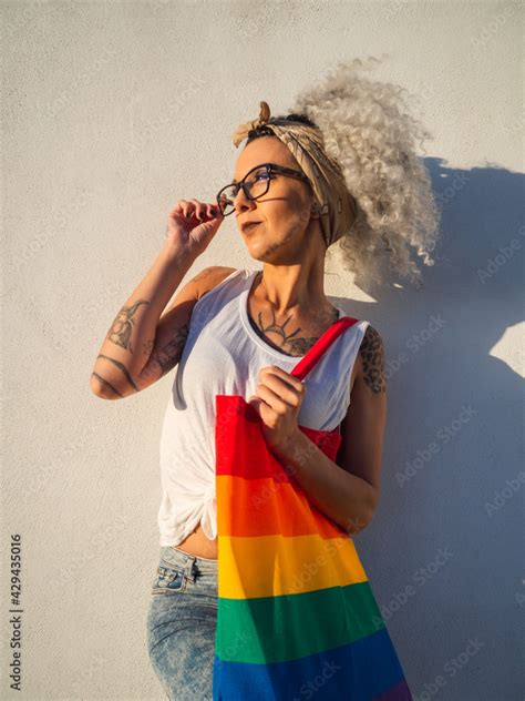 Mujer Joven Con Tatuajes Sujetando Un Bolso Con La Bandera Del Orgullo Gay Stock Photo Adobe Stock