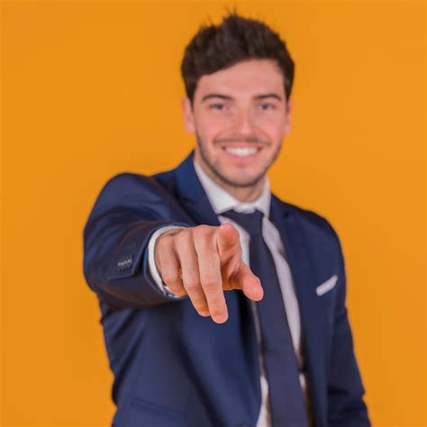 Retrato De Un Hombre Joven Sonriente Que Se Ala Su Dedo Contra Un Fondo