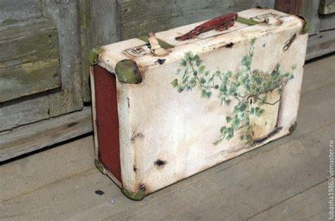 an old suitcase sitting on the floor next to a wooden wall with birds ...
