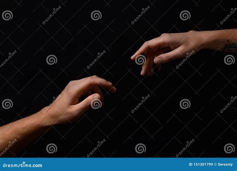 Male And Female Hands Reaching Out To Each Other On Dark Background