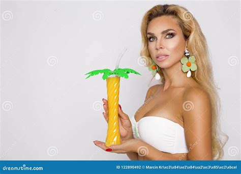 Modelo Hermoso En Un Bikini Llevando A Cabo Una Bebida En Un Fondo Blanco Foto De Archivo