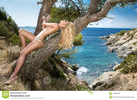Beautiful Blonde Woman In Bikini Sensual Lingerie On The Beach By The Rocks Stock Image