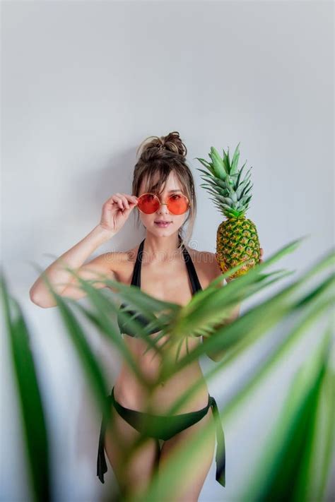 Female In Bikini Holding Pineapple And With Palm Leaves Out Of Focus Stock Image Image Of