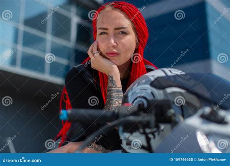 Une Belle Femme Sur Une Moto Penche Son Visage Dans La Main Image Stock