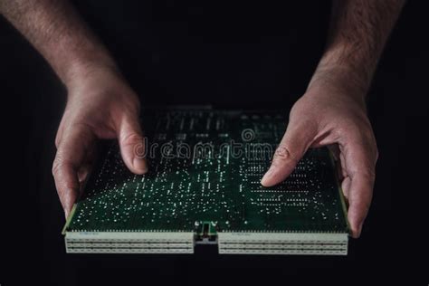 Man Hands Hold A Green Computer Board With A Chip On A Black Backgr