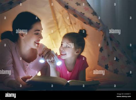 La familia a la hora de acost Mamá y su hija están leyendo un libro con