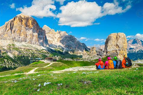 Hikers With Backpacks Sitting And Relaxing In Mountains Dolomites Italy