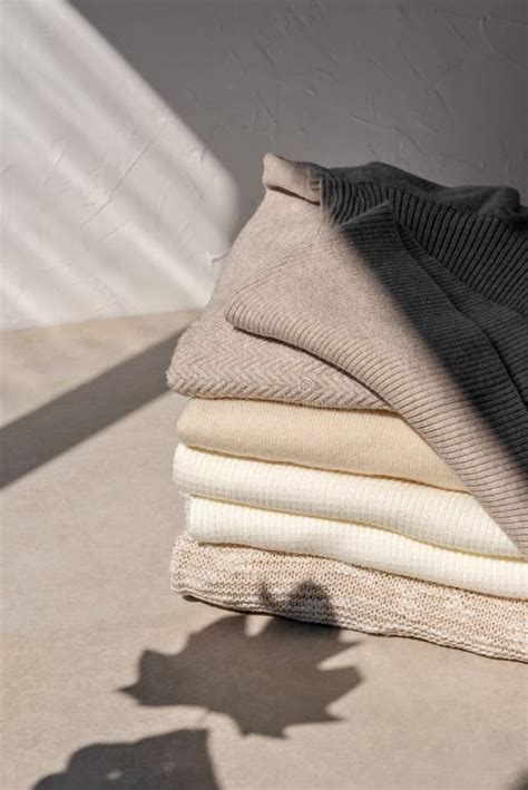 Stack Of Beige Taupe White Light Brown Knitted Sweaters On Neutral