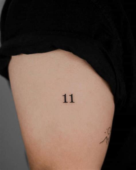 Tattoo of the number "11" located on the upper arm.