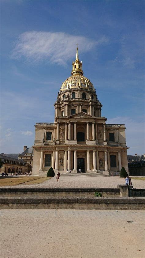 A Large Building With A Golden Dome On Top And People Standing In The