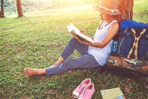 Premium Photo Midsection Of Woman Reading Book While Sitting On Field