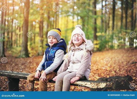 Deux Enfants Riants S Asseyant Sur Un Banc Image Stock Image Du Rire