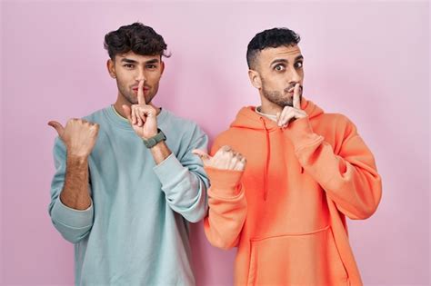 Jovem Casal Gay Hisp Nico Em P Sobre Fundo Rosa Pedindo Para Ficar Quieto O Dedo Nos L Bios
