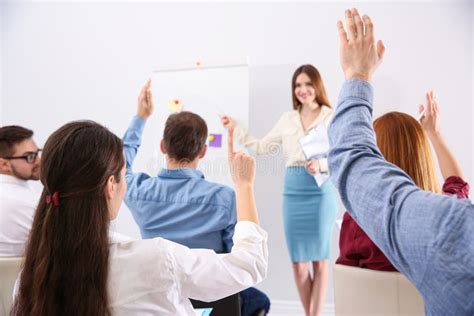 People Raising Hands To Ask Questions At Training Indoors Stock Image