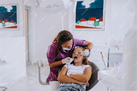 Premium Photo A Cheerful Girl Undergoes A Dental Examination In A Modern Pediatric Dentistry