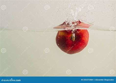 Close Up View Of Red Apple Falling Into Water Isolated On Background