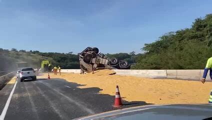 VÍDEO carreta carregada milho tomba na BR 050 e parte da carga cai